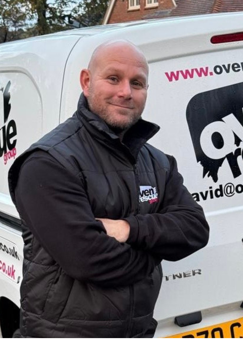 man smiling in front of oven rescue van