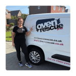 Woman smiling and pointing at an Oven Rescue van with branding and contact information, parked in a residential area. Bright day, welcoming vibe.