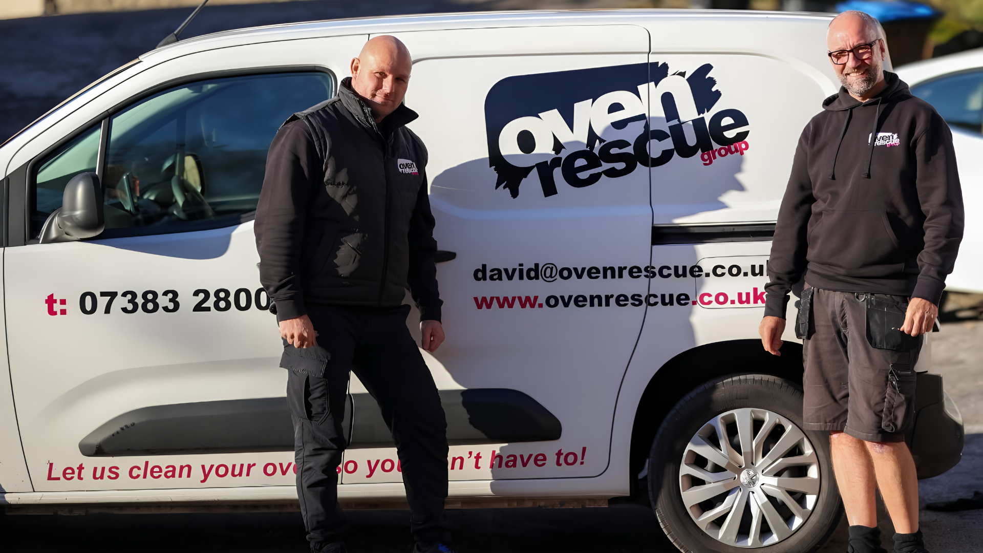 two oven rescue franchisees smiling in front of an oven rescue van